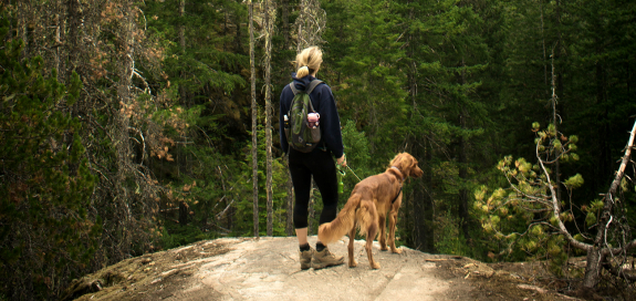 A woman and a dog hiking